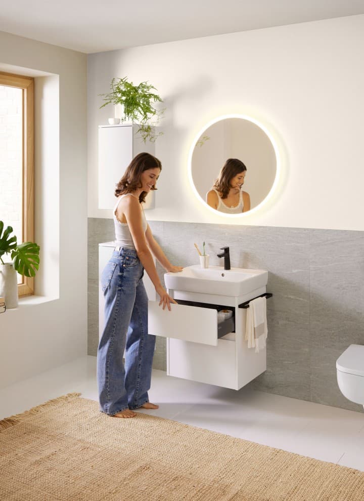 Woman in white bathroom from the Geberit Renova Plan bathroom series Woman in white bathroom from the Geberit Renova Plan bathroom series